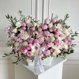 Large pink and white rose arrangement in a white vase
