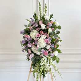 Large pastel floral spray on a wooden easel