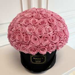 Round bouquet of pink roses in a black hat box