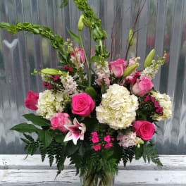 Pink and white mixed flower arrangement in a glass vase