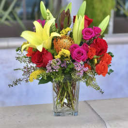 Mixed bouquet of lilies and roses in a clear glass vase