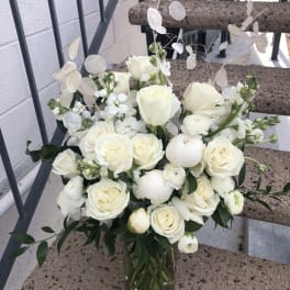 White rose bouquet in a glass vase with airy white filler flowers