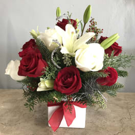 Red and white rose arrangement with lilies in a white box tied with a red ribbon