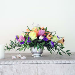 Mixed bouquet of roses and lilies in a silver vase