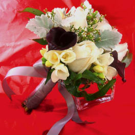 Hand-tied bouquet of white roses, cream blooms, dark calla lilies and silver foliage with a gray ribbon.