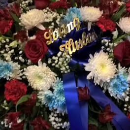 Large floral arrangement with red roses, white chrysanthemums, and blue-dyed blooms