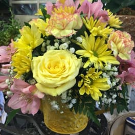 Yellow and pink mixed flower bouquet in a decorative yellow vase