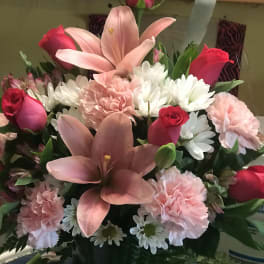 Pink lilies, roses, carnations, and white daisies in a vase
