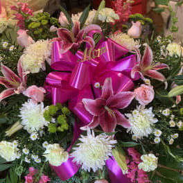 Pink and white floral arrangement with a bright magenta ribbon bow