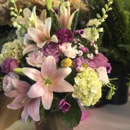 Pink lilies and purple flowers in a vase