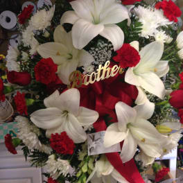 Large red and white funeral wreath with lilies, roses, and carnations