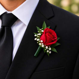 Red rose boutonniere pinned to a black suit jacket