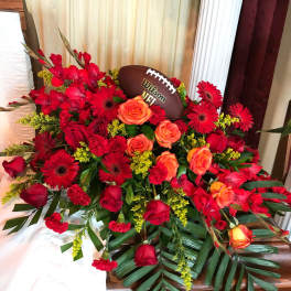Red and orange floral arrangement with a football centerpiece