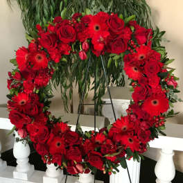Heart-shaped red floral wreath on a stand