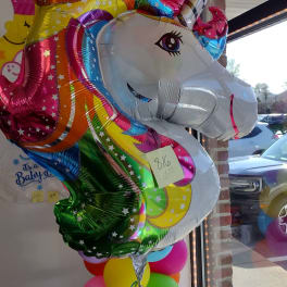 Rainbow unicorn balloon with a cluster of colorful balloons