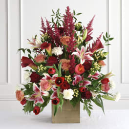 Tall red and pink floral arrangement in a square vase