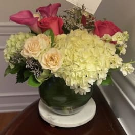 Pink roses and pale hydrangeas arranged in a glass vase
