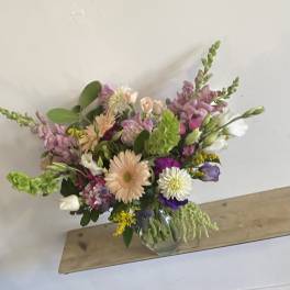 Mixed bouquet in a clear glass vase with pink, white, and purple flowers