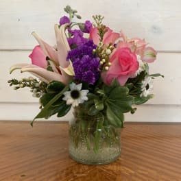 Pink and purple mixed bouquet in a glass jar vase