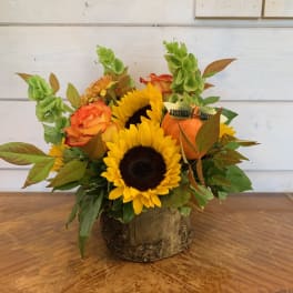 Sunflower and orange rose arrangement in a rustic wood container