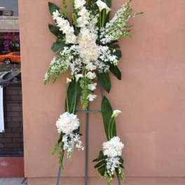 Tall white floral standing spray on a metal easel