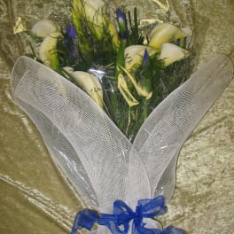 Bouquet of white calla lilies with blue accents wrapped in white mesh