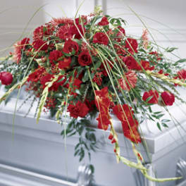 Red floral casket spray with roses and carnations