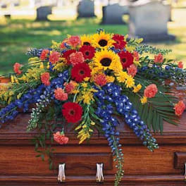 Colorful flower spray on a wooden casket
