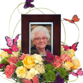 Floral photo frame arrangement with yellow and pink roses and butterfly accents