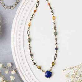 Beaded necklace with a blue pendant on a white display bust