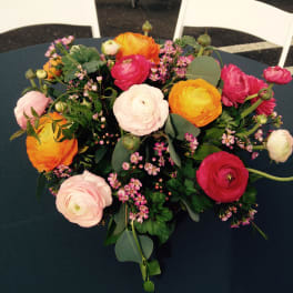 Bouquet of pink, orange, and white ranunculus with small pink filler flowers