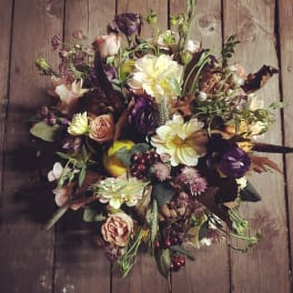 Loose bouquet of mixed flowers in cream, pink, purple, and brown tones
