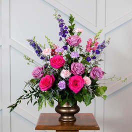 Pink and purple rose arrangement in a bronze vase