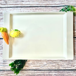 White rectangular serving tray with small vegetable decorations
