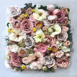 Square bouquet of pastel roses and mixed blooms on a light background