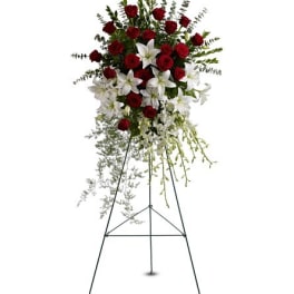 Standing floral spray with red roses and white lilies on an easel