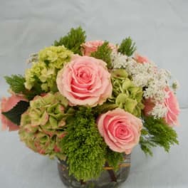 Pink roses and green hydrangeas in a glass vase