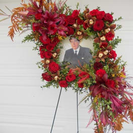 Standing floral wreath with red roses around a portrait photo