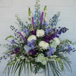 Large blue, purple, and white floral arrangement in a vase