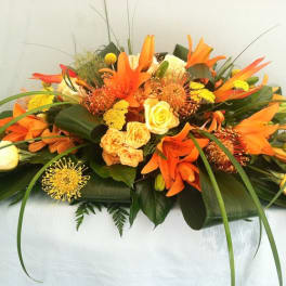 Orange lilies and yellow roses in a low arrangement