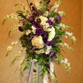 Tall floral spray with purple and white flowers on a stand