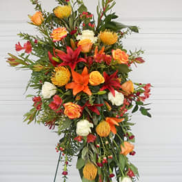 Tall standing floral spray with orange, red, and white blooms