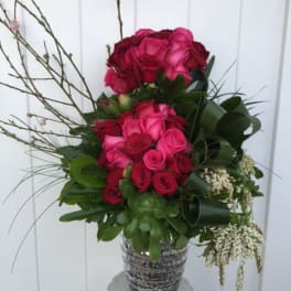 Pink and red rose arrangement in a patterned vase