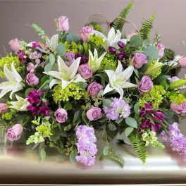Lavender roses and white lilies in a low floral arrangement