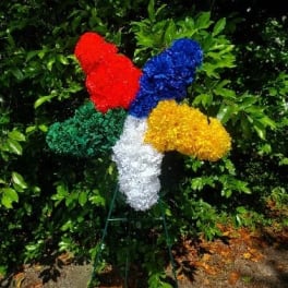 Colorful standing floral spray with red, blue, yellow, white, and green blooms