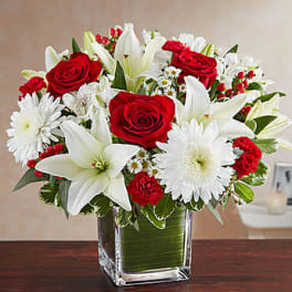 Red roses and white lilies in a clear glass vase