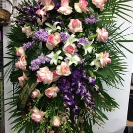 Large standing spray of pink roses, white lilies, and purple orchids