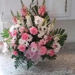 Pink and white floral arrangement with daisies and carnations