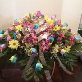 Large colorful floral spray with rainbow roses and pink flowers