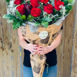 Large bouquet of red roses wrapped in brown paper